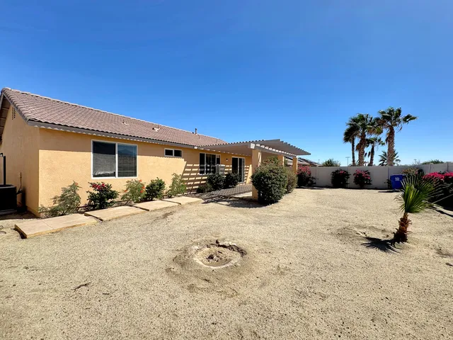 a view of a house with backyard and sitting area