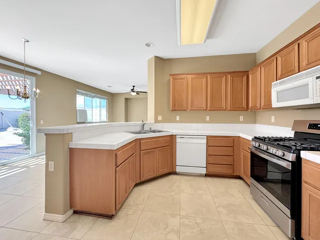 a kitchen with granite countertop stainless steel appliances a stove sink and cabinets