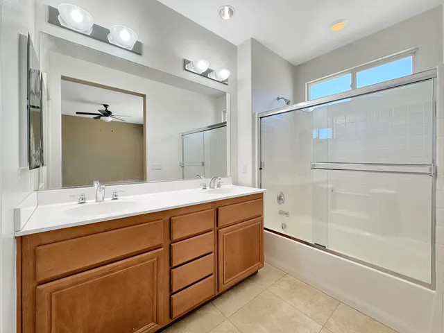 a bathroom with a double vanity sink mirror and shower