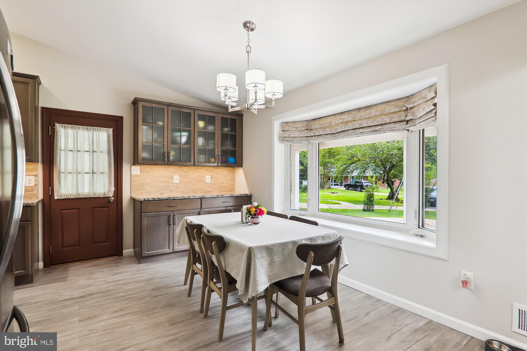 11804 Lovejoy Street Silver Spring, MD 20902 - Photo 18 of 45 a dining room with wooden floor a chandelier a wooden table and chairs