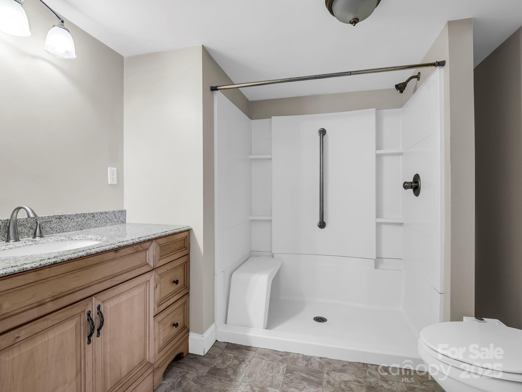 264 Goode Road Mooresboro, NC 28114 - Photo 14 of 36 a bathroom with a granite countertop sink a toilet and shower
