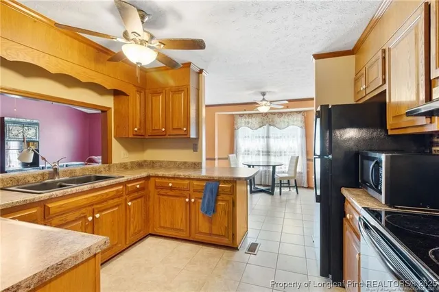 a kitchen with stainless steel appliances granite countertop a sink and a refrigerator