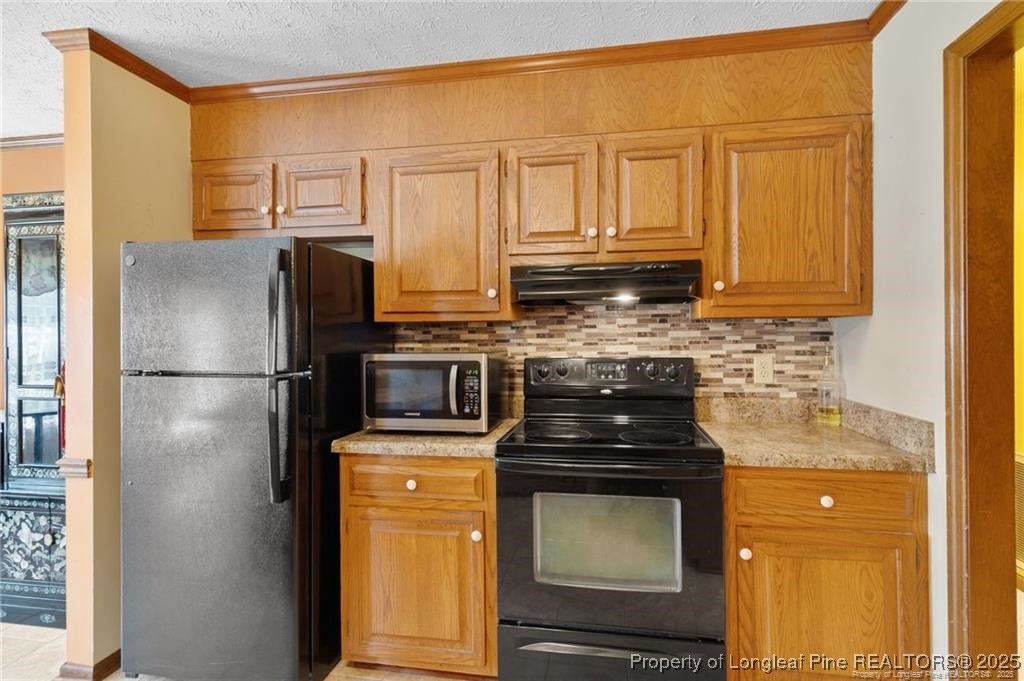 6104 Sisk Culbreth Road Godwin, NC 28344 - Photo 9 of 16 a kitchen with stainless steel appliances granite countertop a refrigerator a stove and a sink