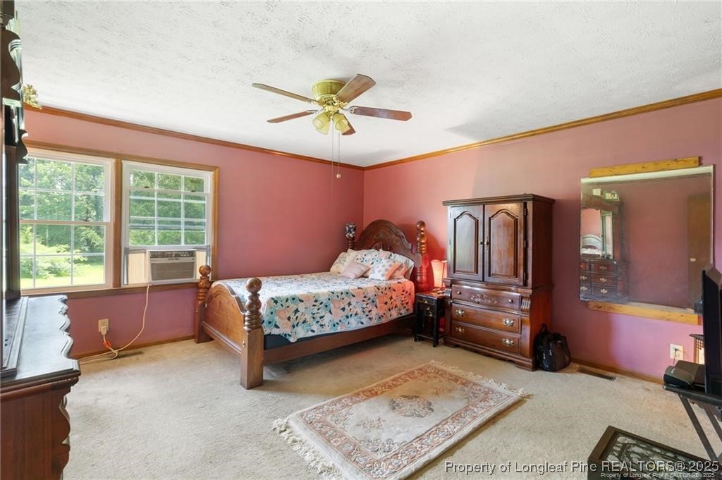 6104 Sisk Culbreth Road Godwin, NC 28344 - Photo 10 of 16 a bedroom with a bed and a chandelier
