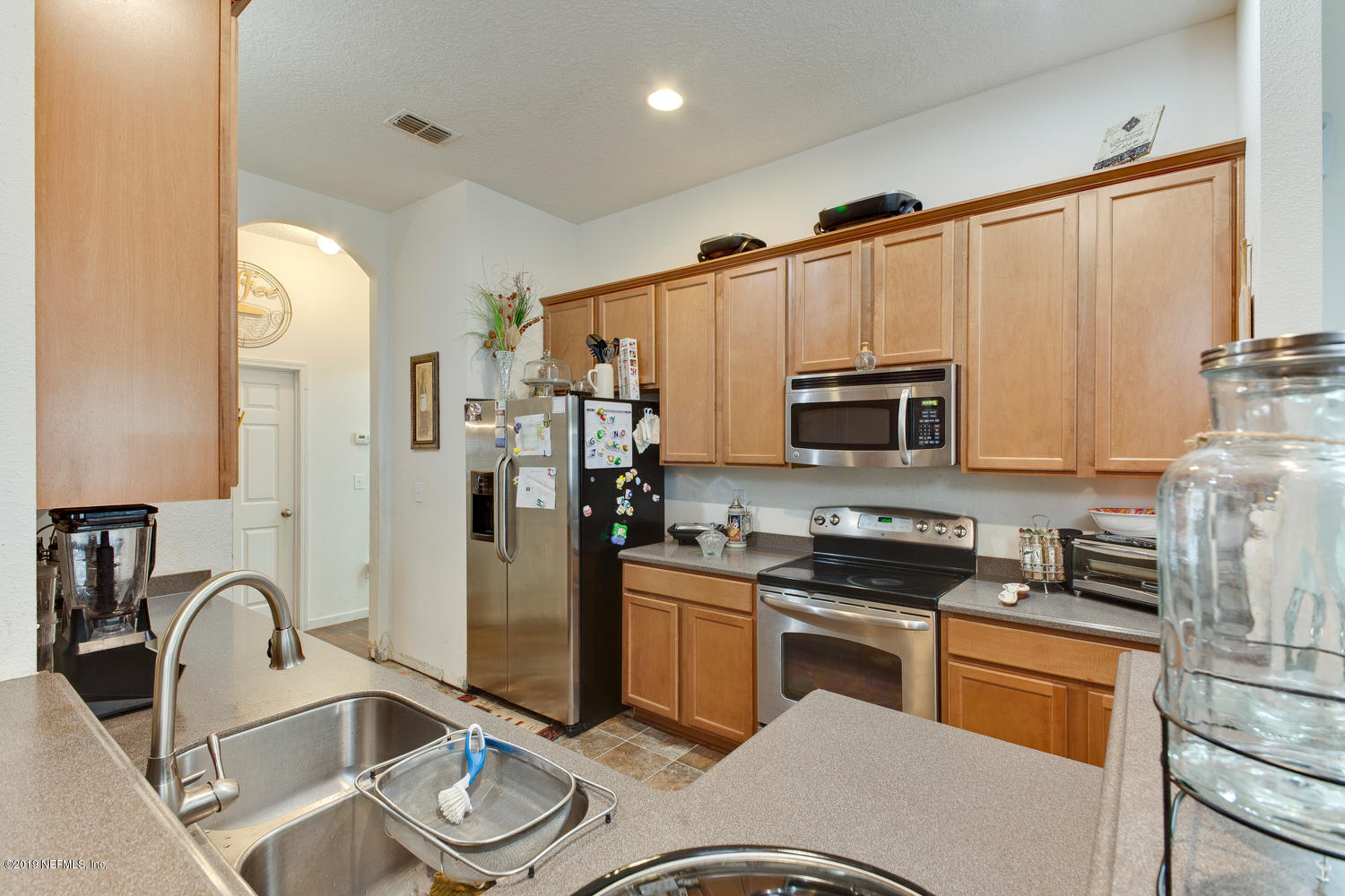 16357 Tisons Bluff Road Jacksonville, FL 32218 - Photo 11 of 31 a kitchen with stainless steel appliances granite countertop a refrigerator sink and stove