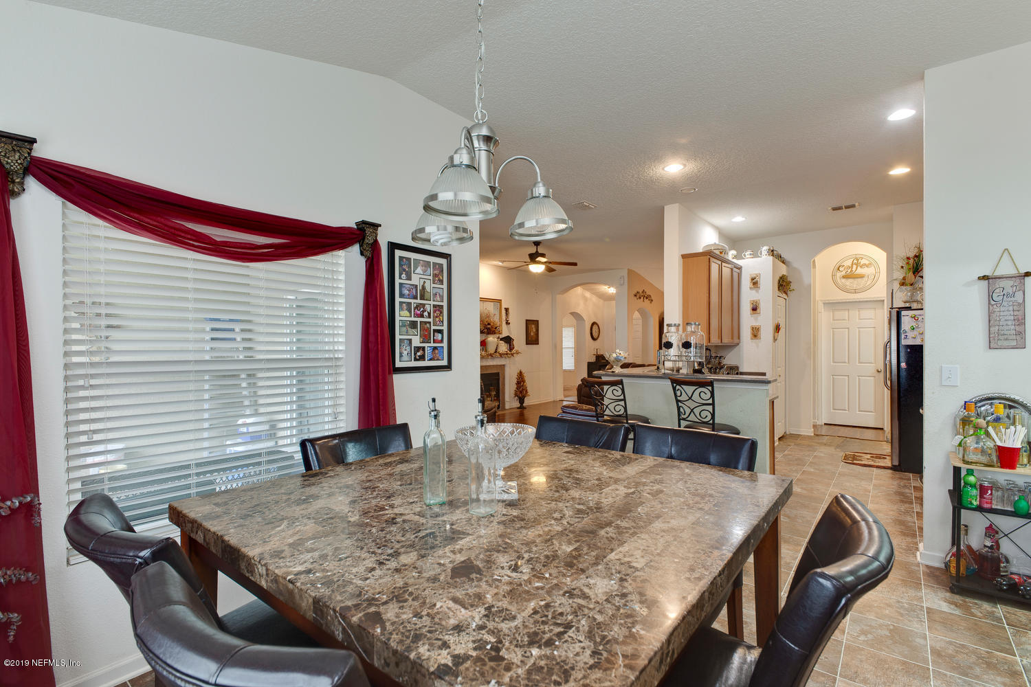 16357 Tisons Bluff Road Jacksonville, FL 32218 - Photo 13 of 31 a kitchen with kitchen island a sink table and chairs