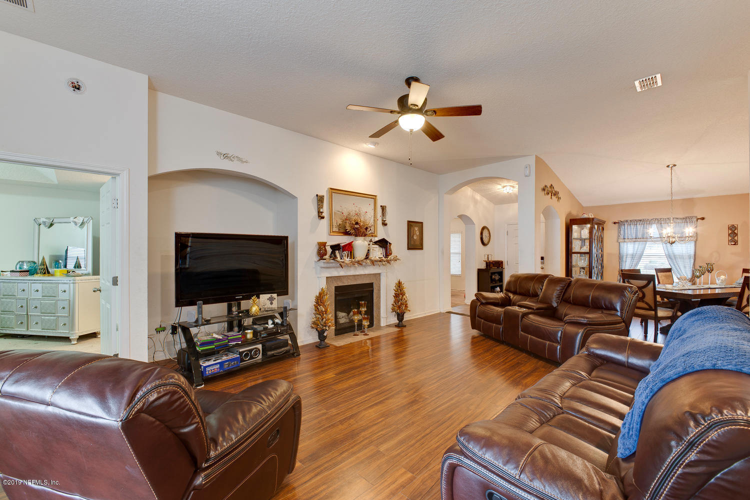16357 Tisons Bluff Road Jacksonville, FL 32218 - Photo 14 of 31 a living room with furniture a flat screen tv and a fireplace