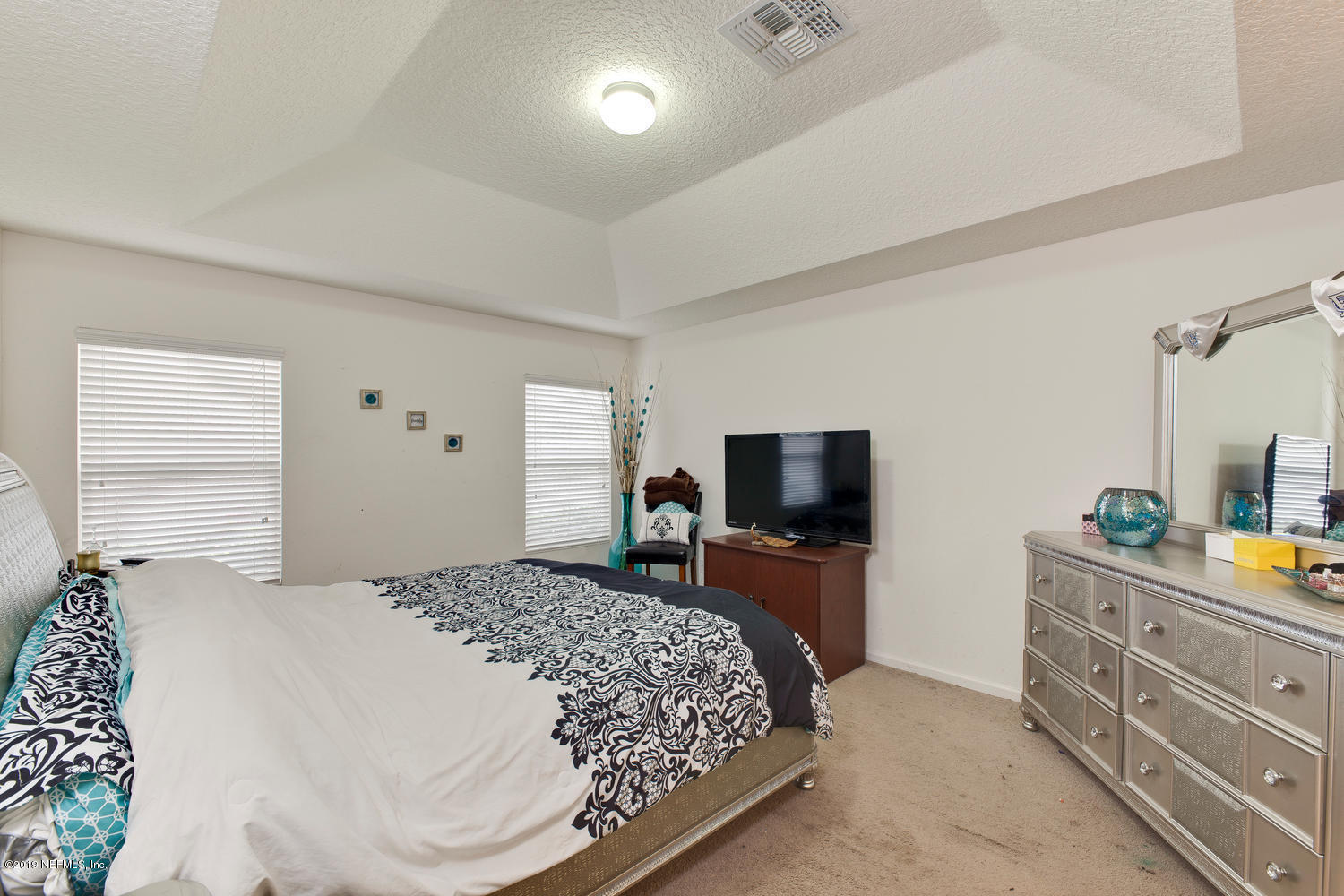 16357 Tisons Bluff Road Jacksonville, FL 32218 - Photo 17 of 31 a bedroom with a bed and a flat screen tv