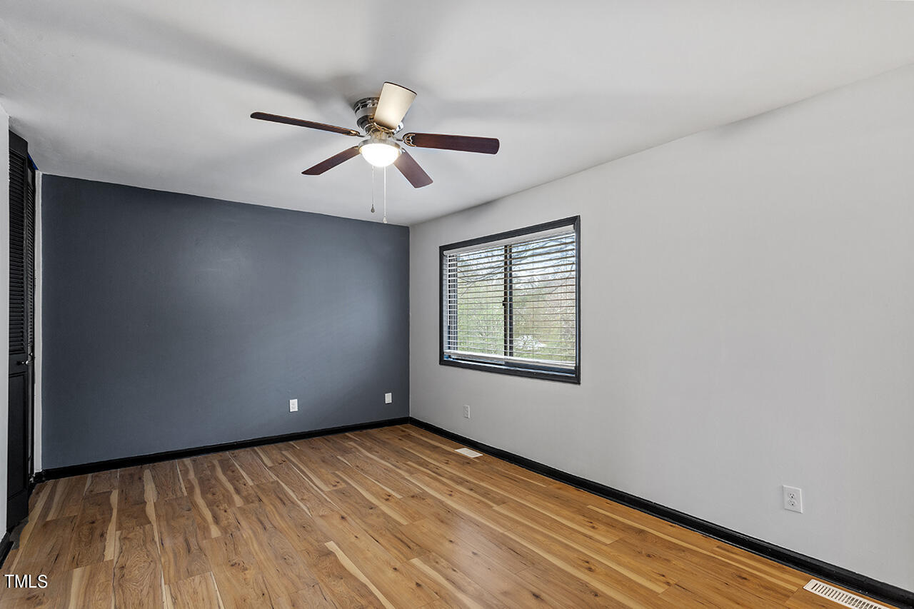 4274 Lake Ridge Drive Raleigh, NC 27604 - Photo 23 of 32 a view of an empty room with wooden floor and a window