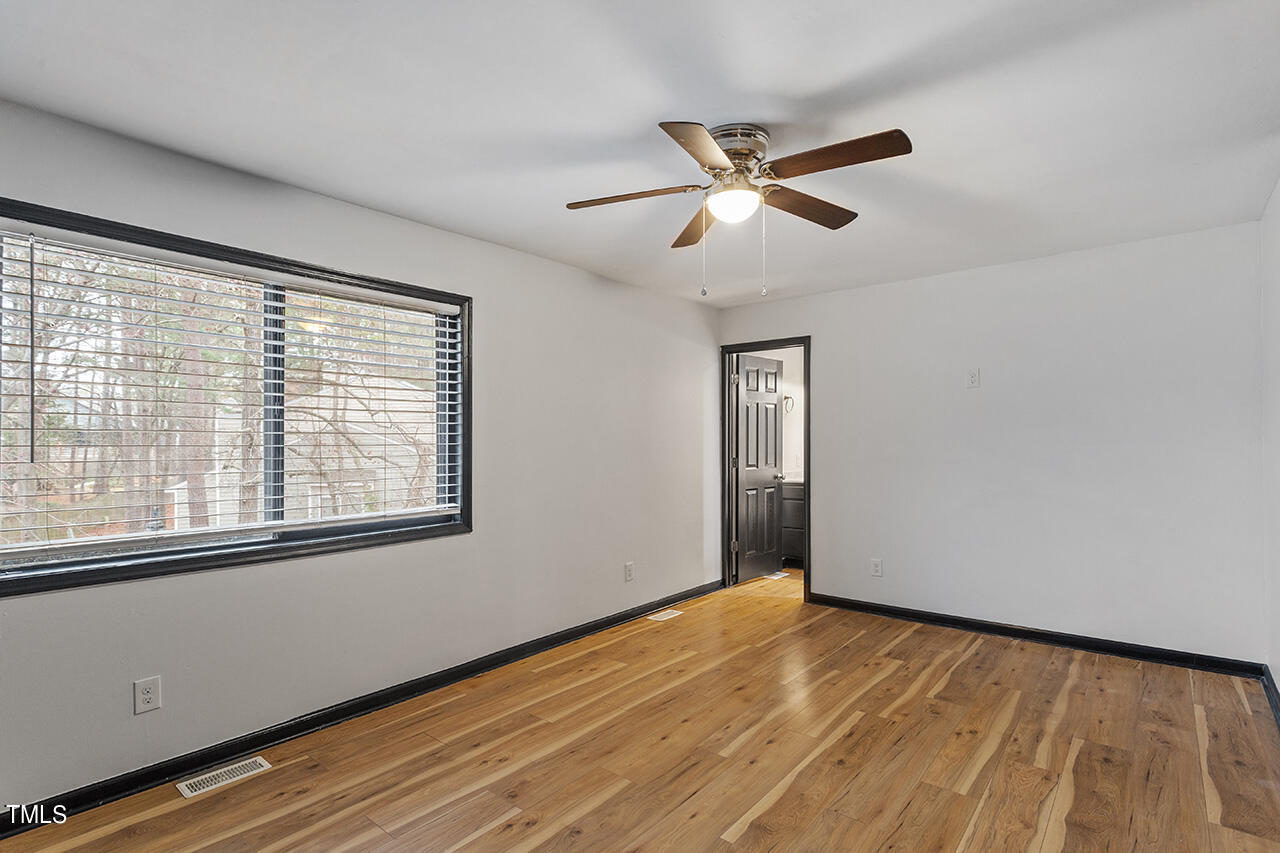 4274 Lake Ridge Drive Raleigh, NC 27604 - Photo 24 of 32 a view of an empty room with wooden floor and a window