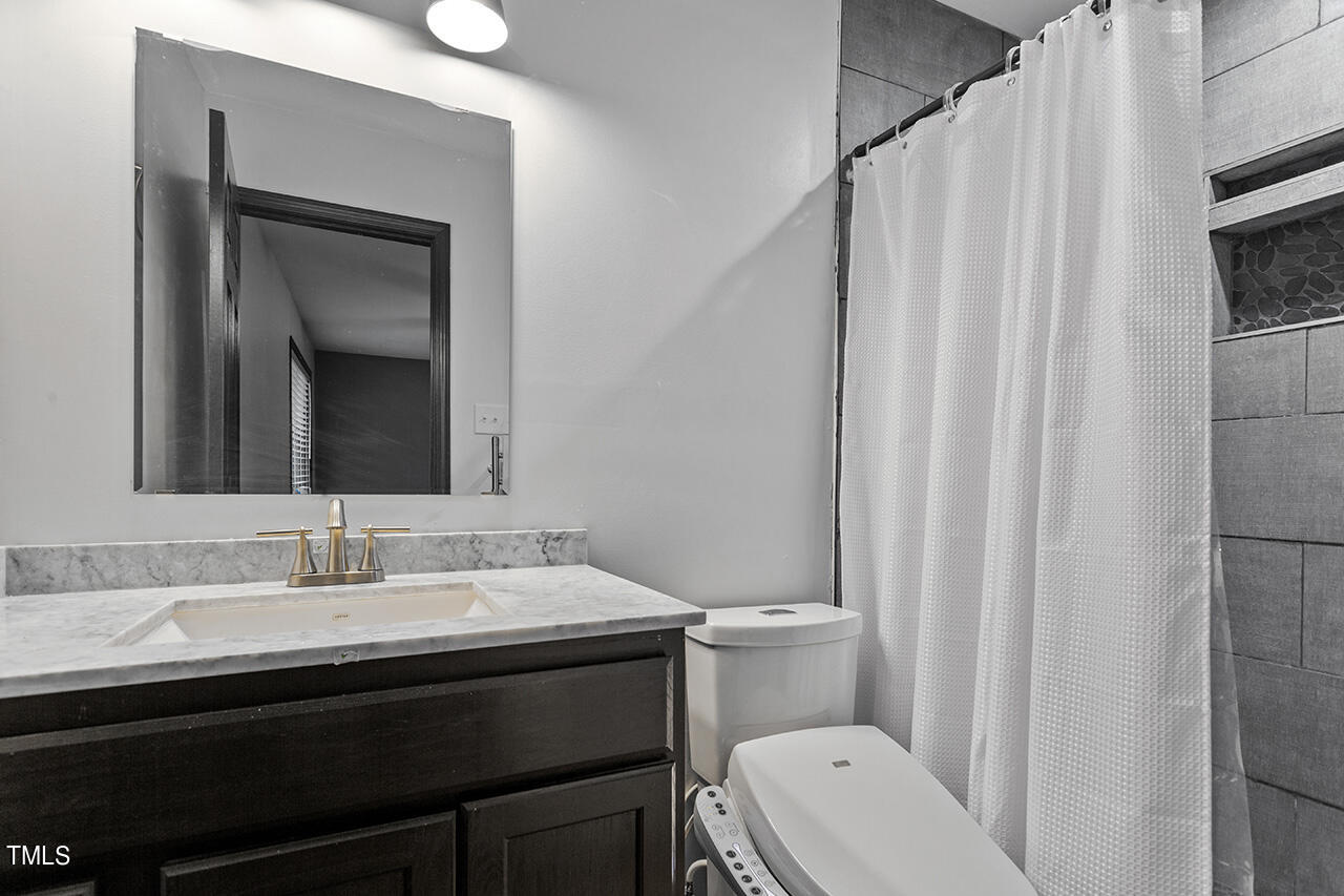4274 Lake Ridge Drive Raleigh, NC 27604 - Photo 25 of 32 a bathroom with a toilet a sink and a mirror