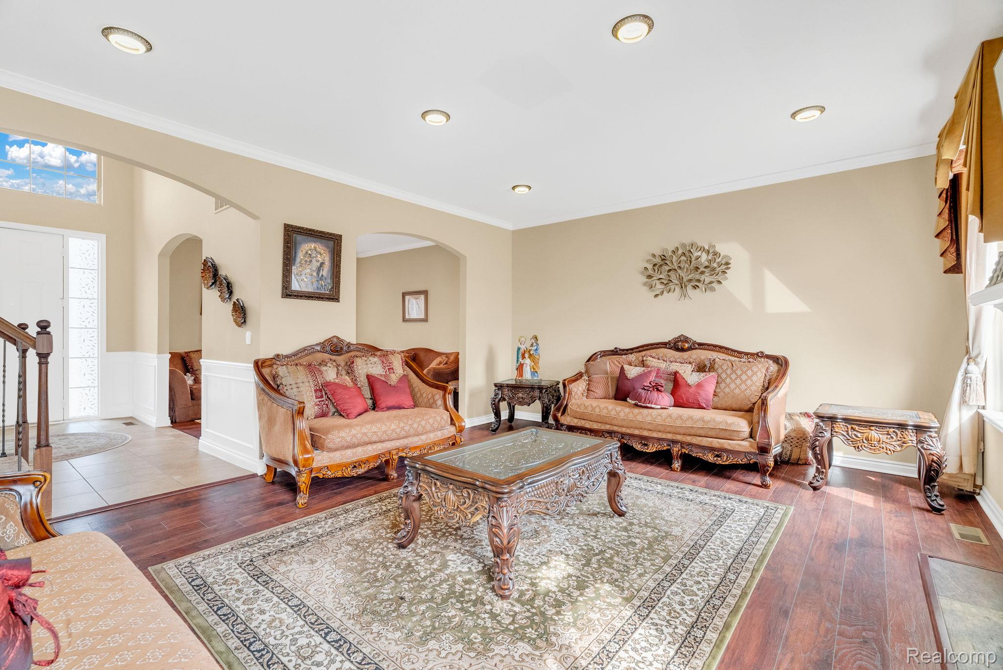 4122 Hawks Nest Road Utica, MI 48317 - Photo 23 of 74 Living room with ornamental molding, a wainscoted wall, dark wood finished floors, and arched walkways