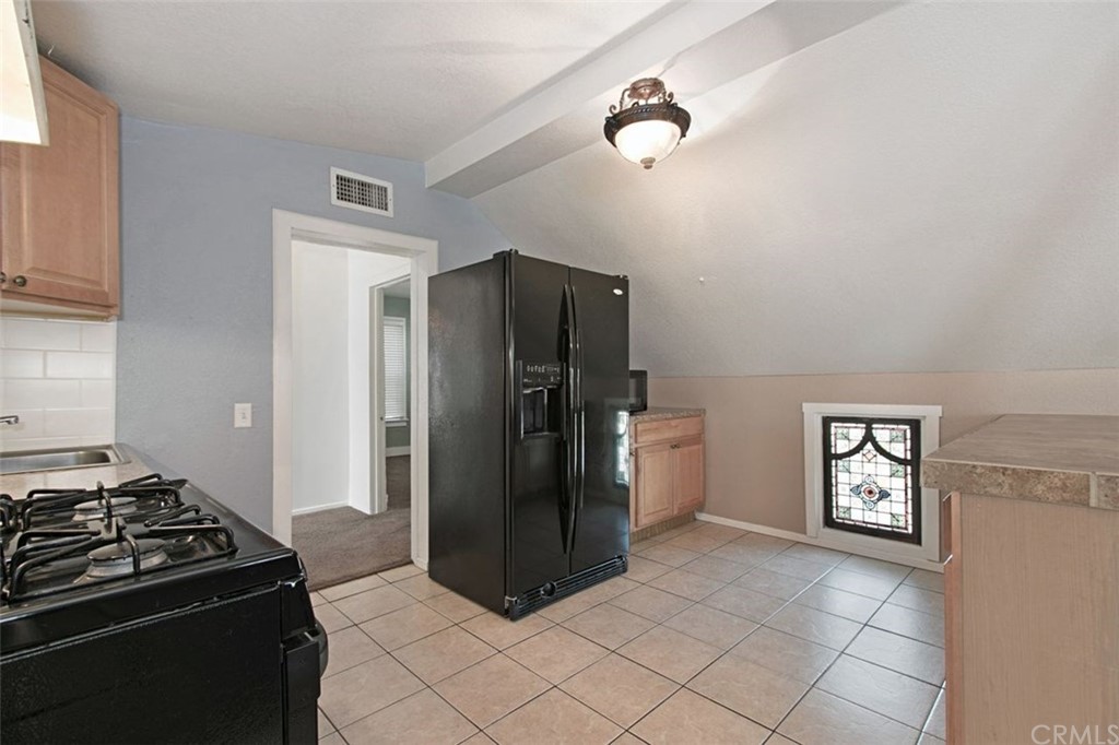 4256 9th Street Riverside, CA 92501 - Photo 29 of 40 a kitchen with a refrigerator and a stove top oven