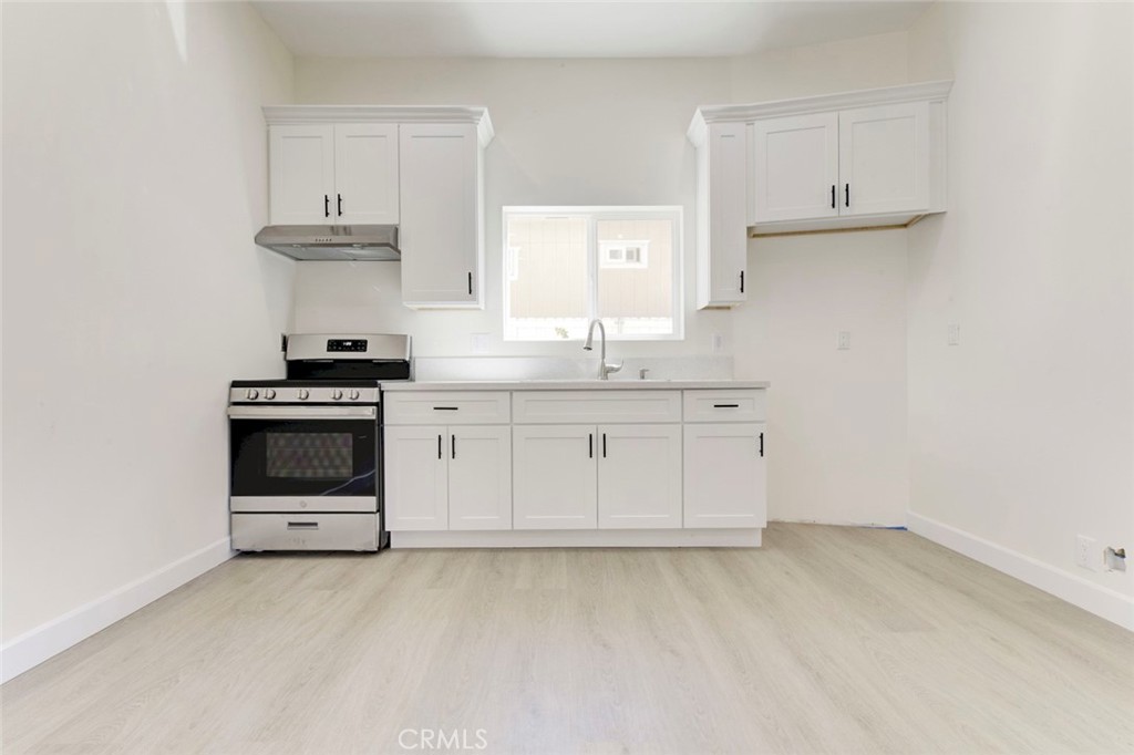 7044-2 Greeley Street Tujunga, CA 91042 - Photo 6 of 20 a kitchen with granite countertop a stove a sink and a granite counter tops