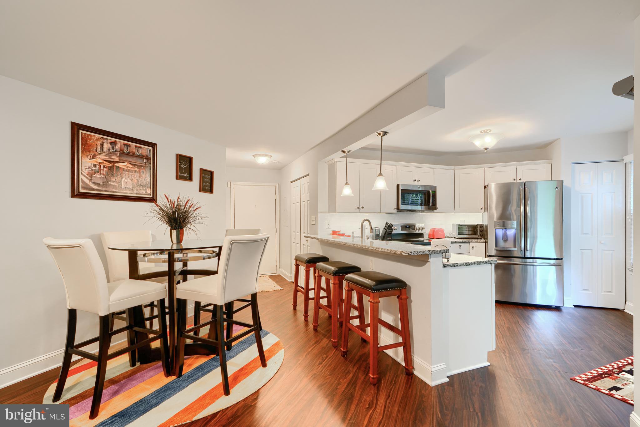 40 Surrey Lane, Unit 122 Nottingham, MD 21236 - Photo 11 of 31 a kitchen with stainless steel appliances granite countertop a refrigerator a stove top oven a sink dishwasher and white cabinets with wooden floor