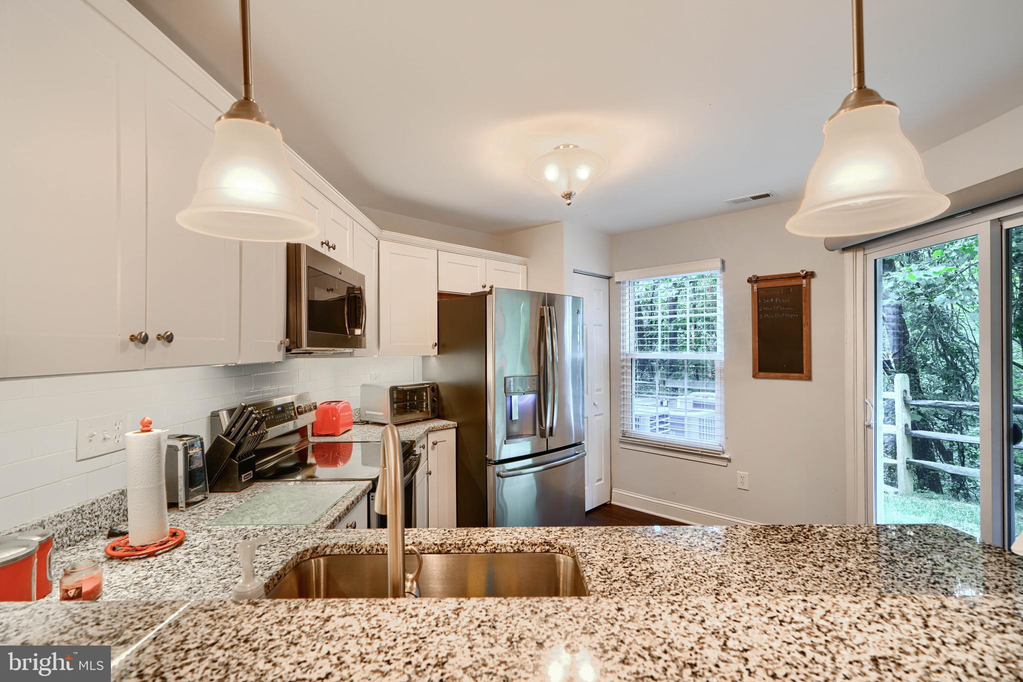 40 Surrey Lane, Unit 122 Nottingham, MD 21236 - Photo 5 of 31 a kitchen with stainless steel appliances granite countertop a sink refrigerator and microwave