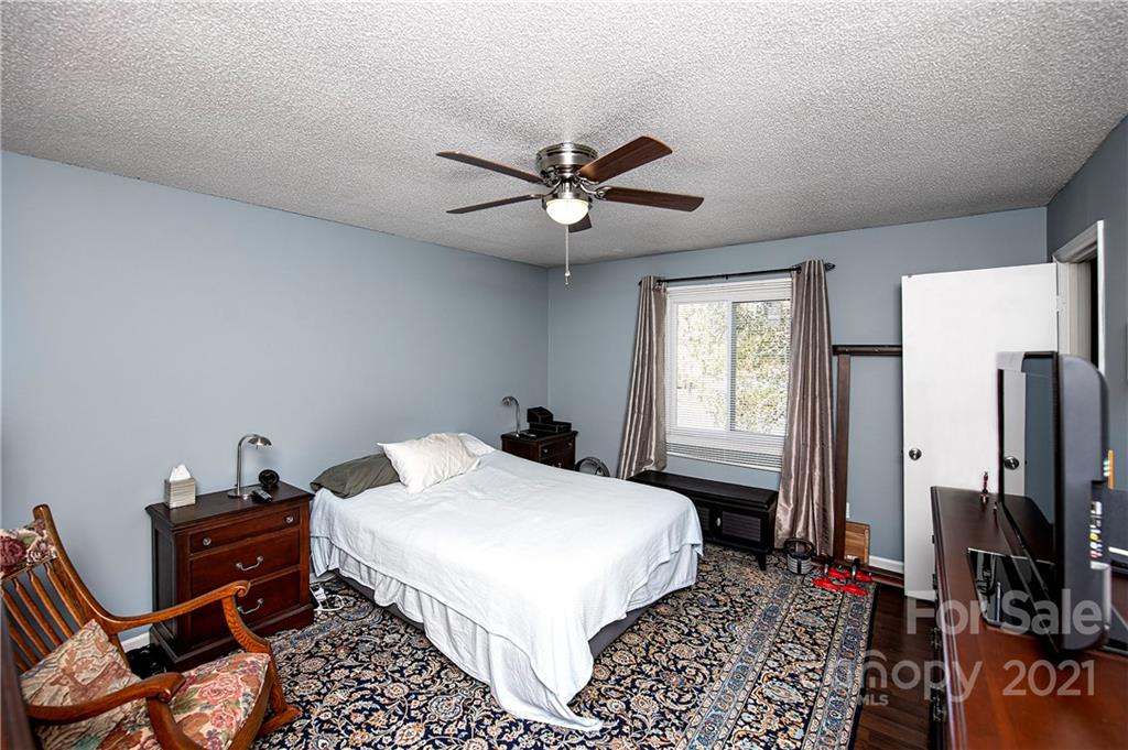 1911 Smoke Ridge Court Charlotte, NC 28210 - Photo 11 of 15 a bedroom with a bed and a chandelier