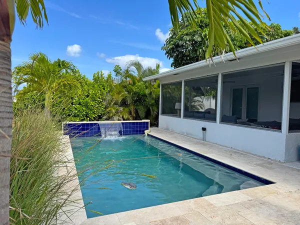 a view of a swimming pool with a patio and a garden