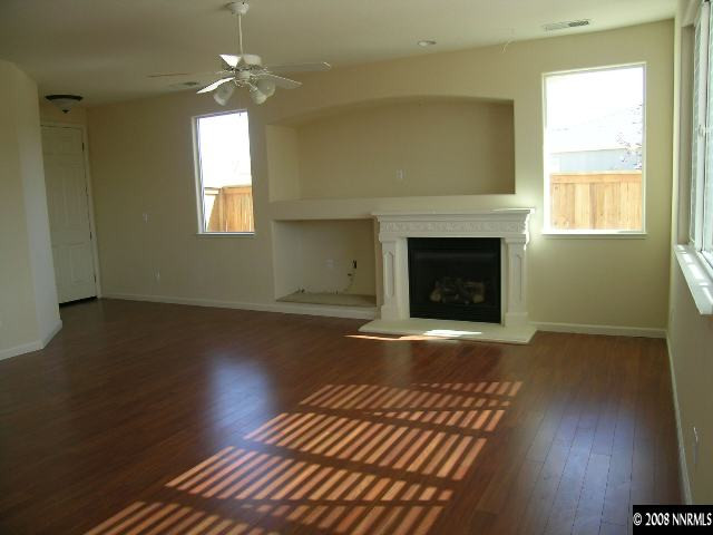 1705 Canyon Shadow Circle Reno, NV 89521 - Photo 3 of 8 an empty room with wooden floor fireplace and windows