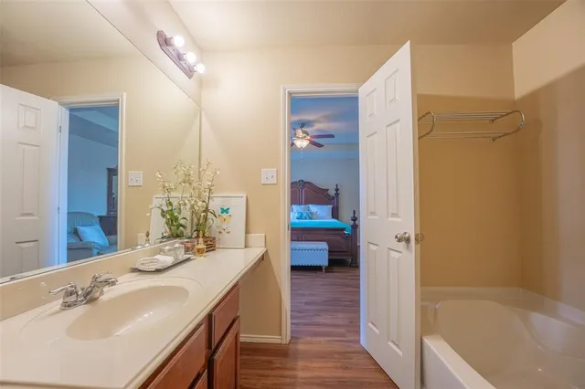 a spacious bathroom with a tub sink and mirror