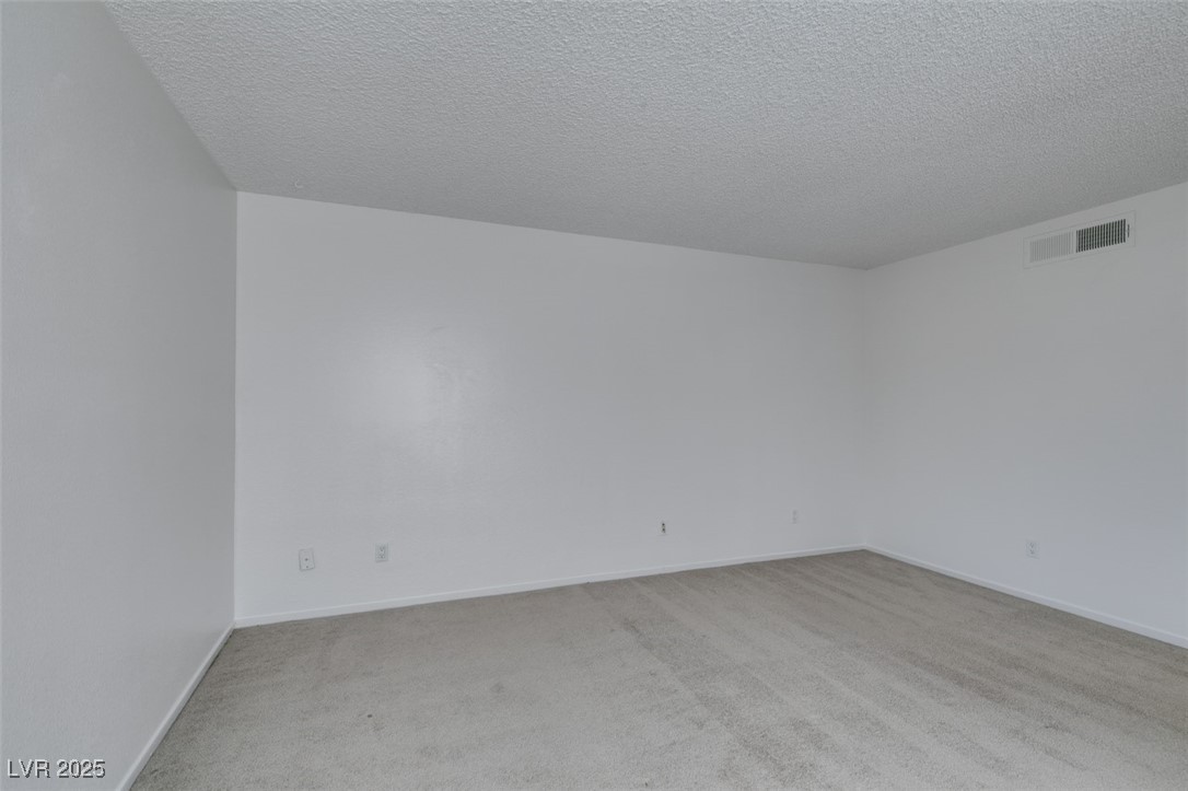 2681 Ruthe Duarte Avenue Las Vegas, NV 89121 - Photo 35 of 43 Spare room with a textured ceiling, baseboards, light carpet, and visible vents