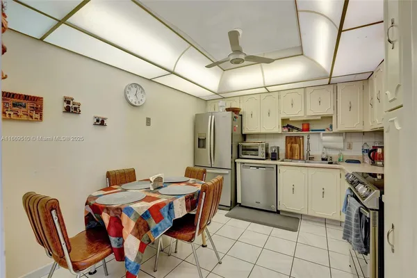 a kitchen with stainless steel appliances granite countertop a dining table and chairs