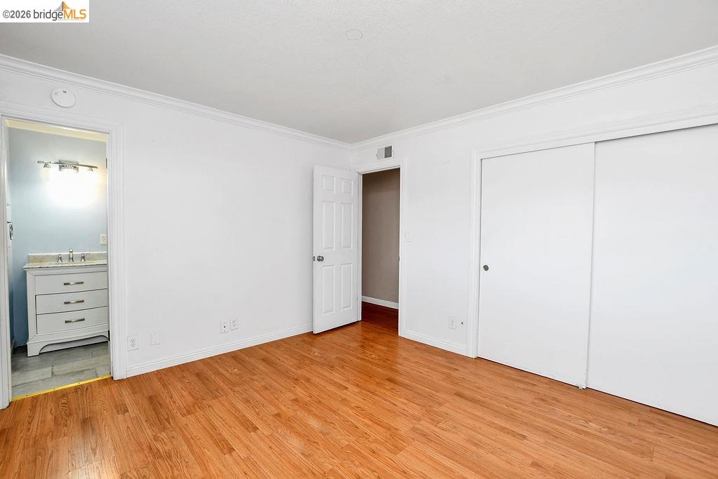 805 Calero Street Milpitas, CA 95035 - Photo 13 of 23 Light-filled room featuring wood-finish flooring, white walls, and crown molding