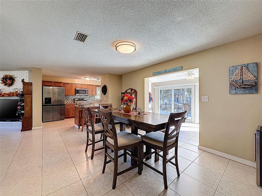 8716 Green Street Port Richey, FL 34668 - Photo 11 of 42 a view of a dining room with furniture and a potted plant