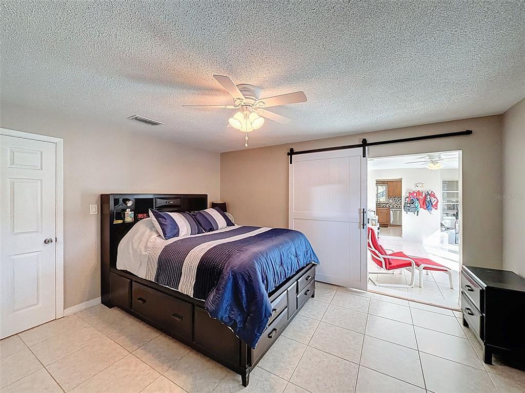 8716 Green Street Port Richey, FL 34668 - Photo 19 of 42 a bedroom with a bed and a chandelier