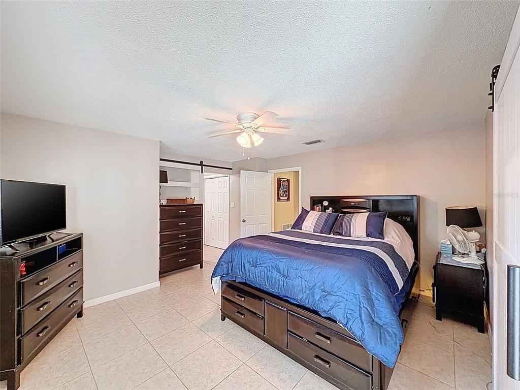 8716 Green Street Port Richey, FL 34668 - Photo 20 of 42 a bedroom with a bed and a flat screen tv
