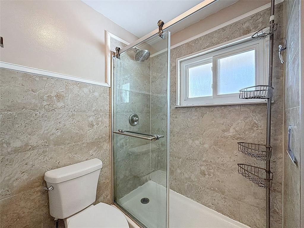 8716 Green Street Port Richey, FL 34668 - Photo 23 of 42 a bathroom with a shower a toilet and a sink