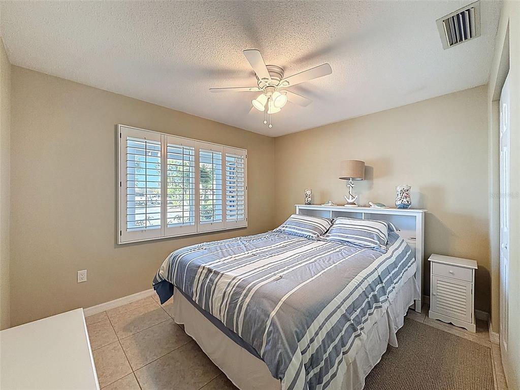 8716 Green Street Port Richey, FL 34668 - Photo 24 of 42 a bedroom with a bed and a chandelier