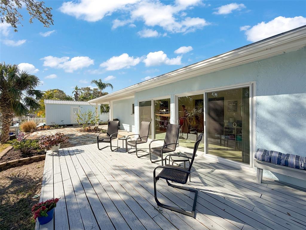 8716 Green Street Port Richey, FL 34668 - Photo 29 of 42 a view of a patio with table and chairs with wooden floor and fence