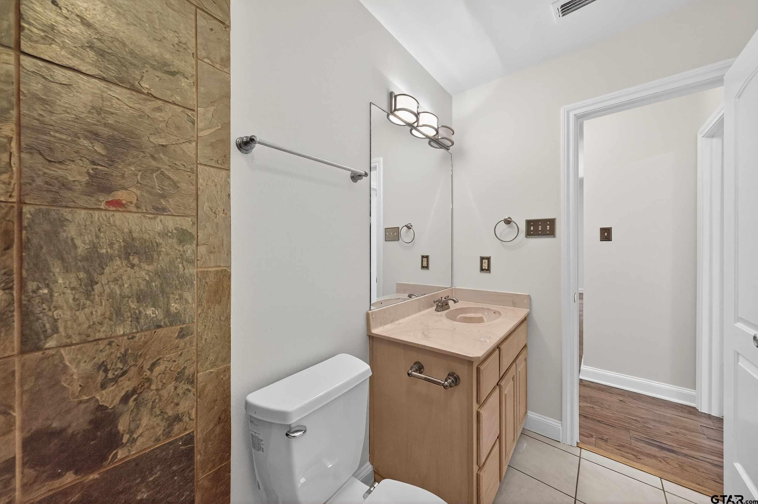 21112 Altuda Lane Flint, TX 75762 - Photo 31 of 48 a bathroom with a granite countertop sink a toilet and a shower