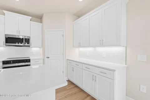 a kitchen with a sink window and wooden floor