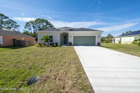 a view of a house with a patio and a yard
