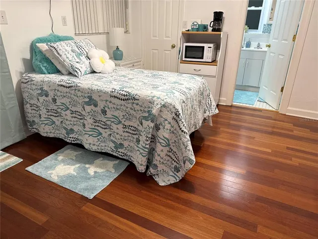 a bedroom with a bed and wooden floor