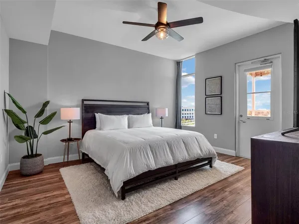 a bedroom with a bed lamps and wooden floor