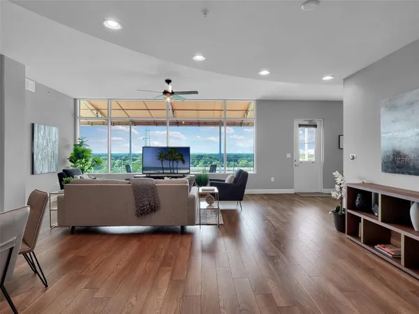 a living room with furniture a window and a flat screen tv