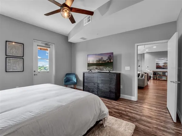 a bedroom with a bed and a flat tv screen on dresser