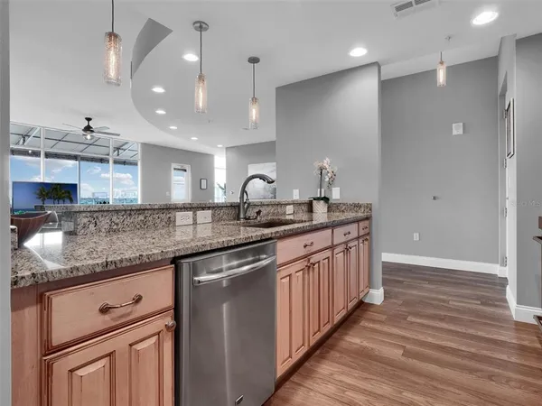 a kitchen with stainless steel appliances granite countertop a refrigerator a stove a sink and a microwave