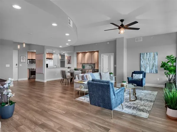 a living room with furniture and a wooden floor