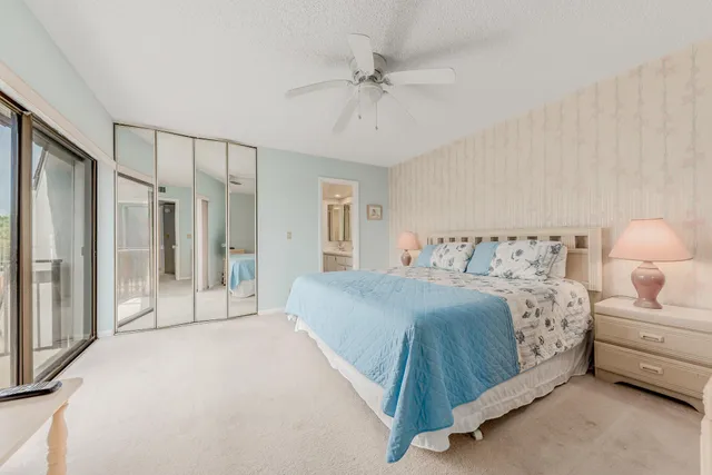 a spacious bedroom with a bed a couch and a chandelier