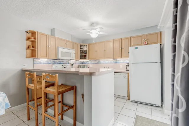 a kitchen with stainless steel appliances granite countertop a refrigerator a stove a sink dishwasher and a refrigerator with wooden floor