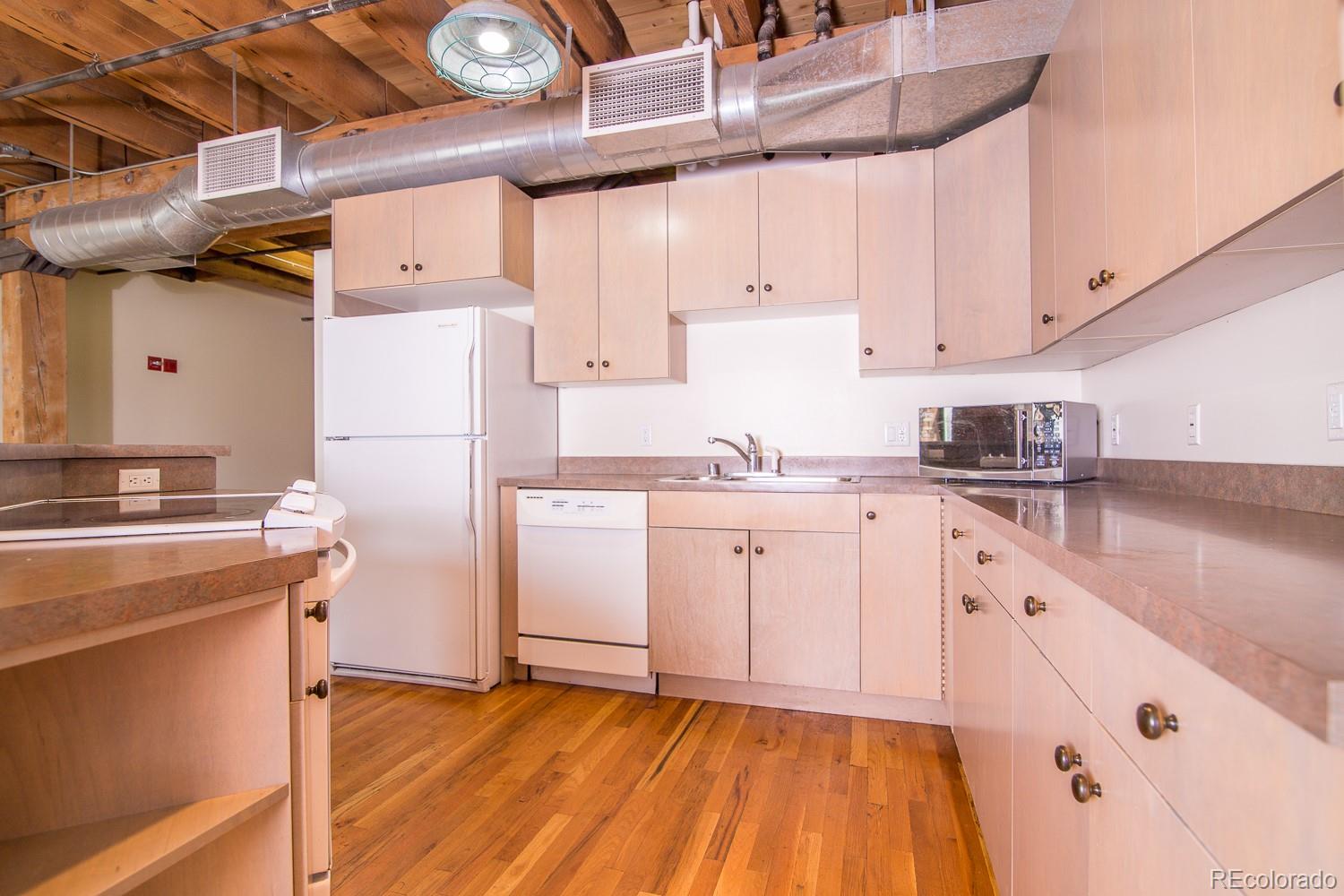 1801 Wynkoop Street, Unit 315 Denver, CO 80202 - Photo 9 of 26 a kitchen with cabinets and wooden floor
