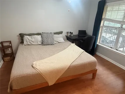 a bedroom with a bed and wooden floor