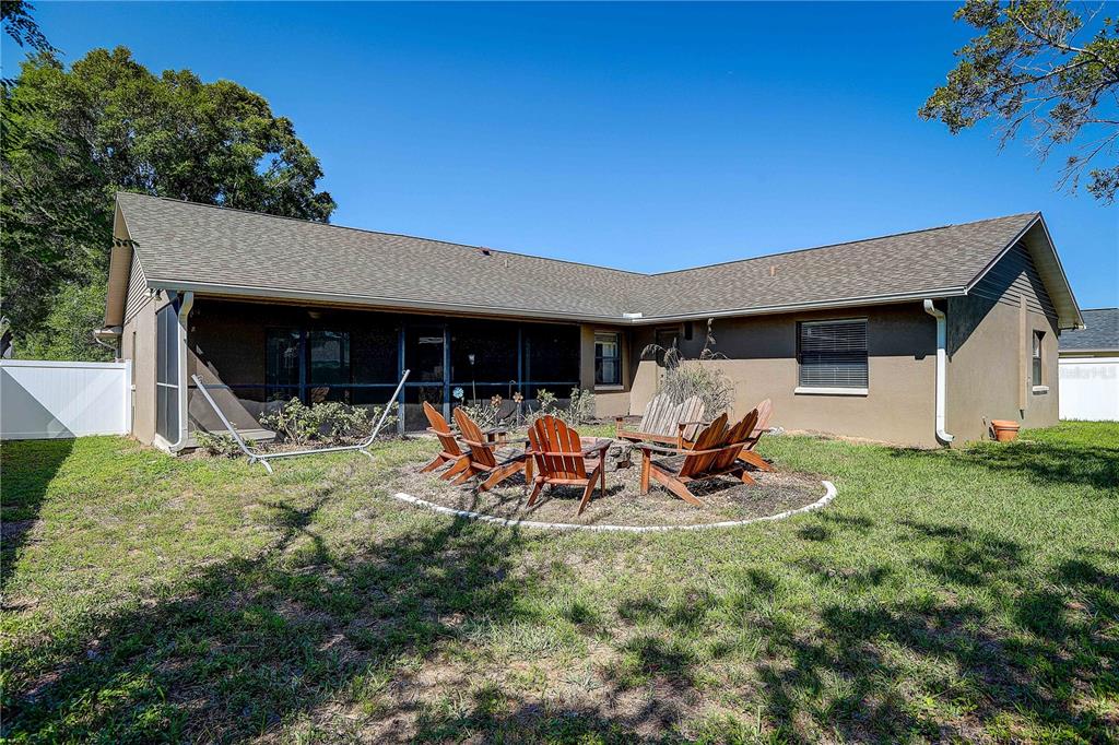 1418 Buckner Road Valrico, FL 33596 - Photo 34 of 37 a view of a patio with table and chairs under an umbrella with large trees