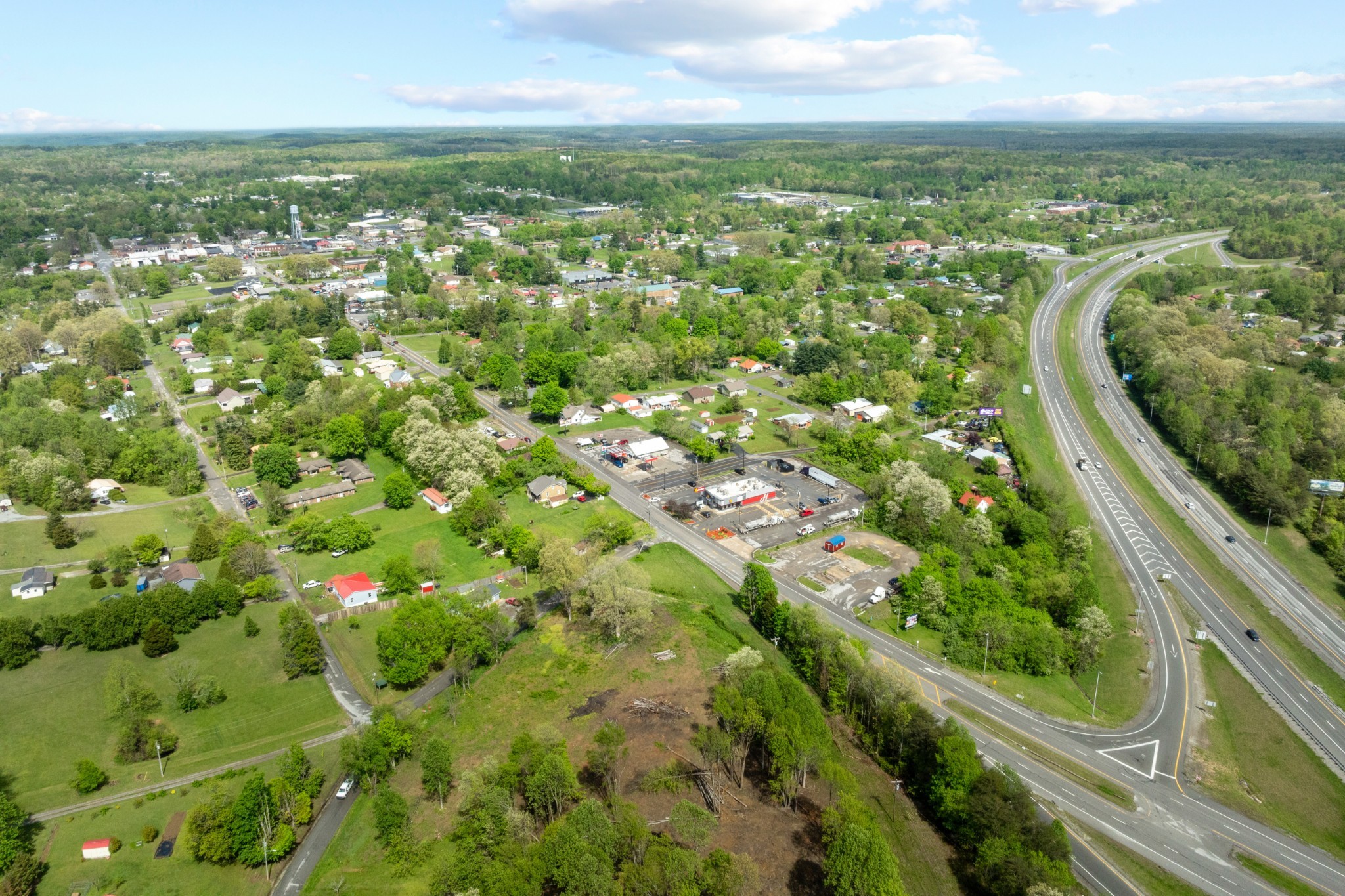 an aerial view of residential houses with outdoor space and trees