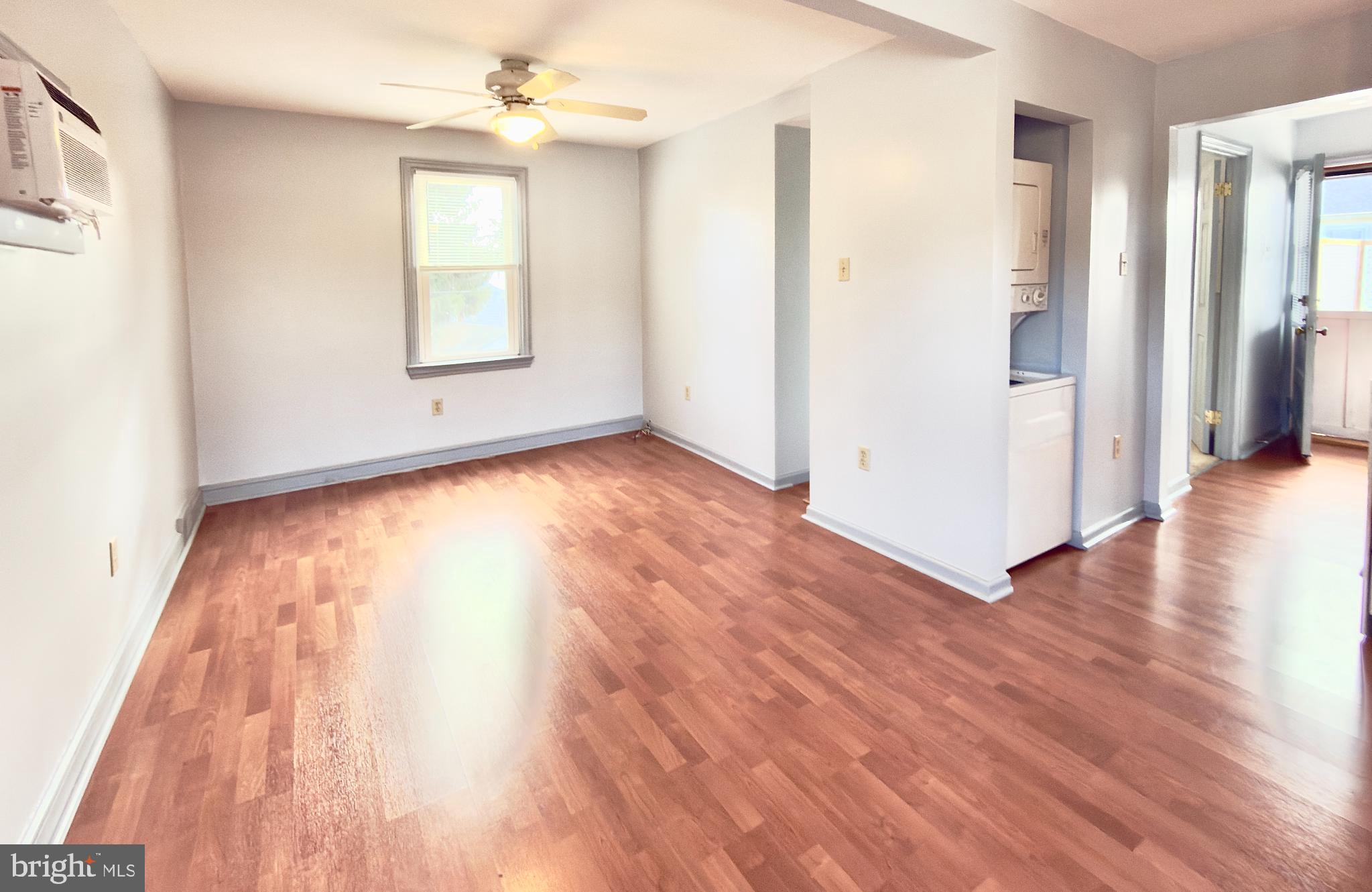 532 Lehigh Avenue, Unit 2 Swarthmore, PA 19081 - Photo 6 of 7 an empty room with wooden floor chandelier and windows