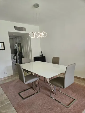 a room with table chairs and wooden floor